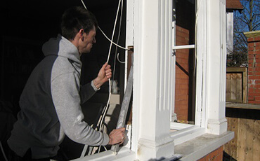 Man working on fixing a window.